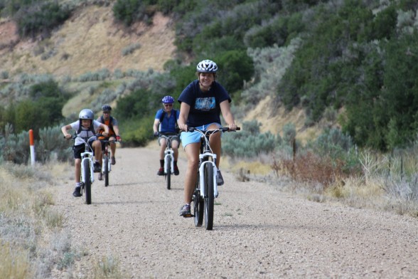 family of three riding their bicycles on a dirt and gravel bike path