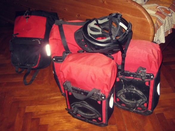 Red ortlieb bicycle touring panniers and a black bicycle helmet