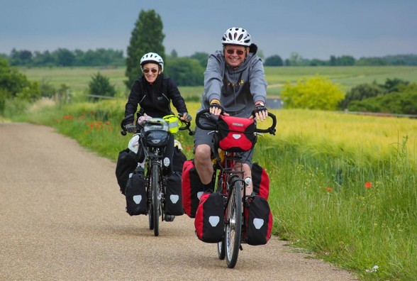 smiling couple on loaded bicycle tour in france