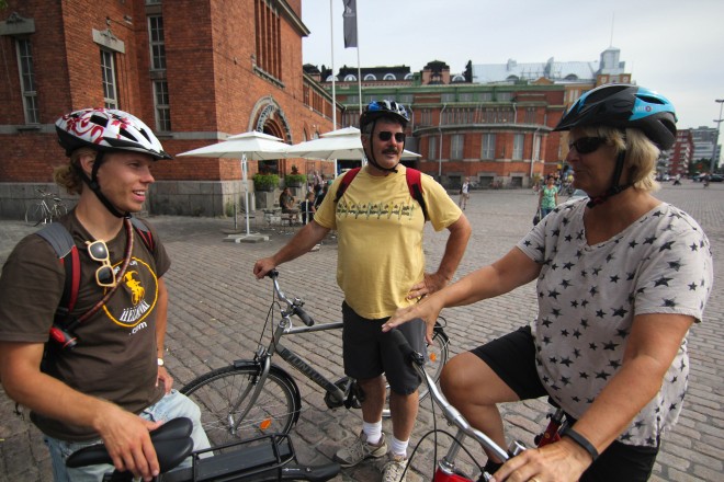 three people on bicycles touring around Helsinki