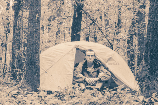 man-camping-in-forest-tent