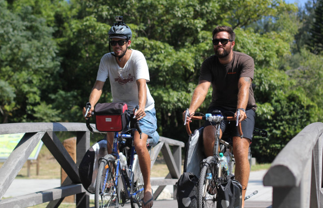 Dylan Brayshaw and Rian Cope riding bicycles over bridge