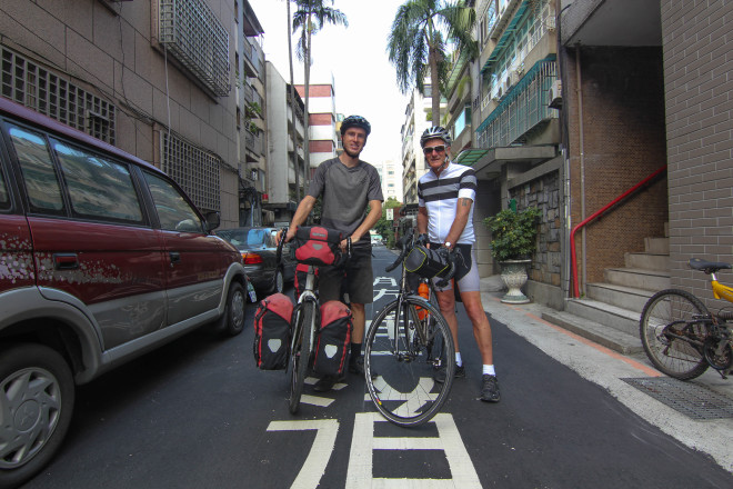 Darren Alff and Kevin Burrett posing with their bicycles at the start of their bicycle tour around the island of Taiwan