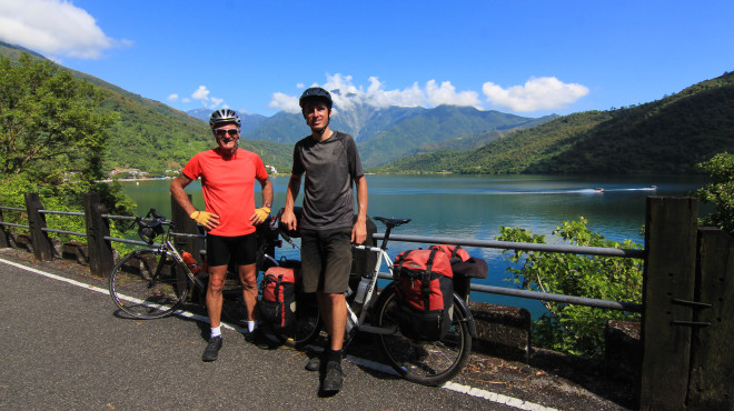 Bicycle TOuring Pro Darren Alff and friend Kevin Burrett smile for a photo with their loaded bicycles at Taiwan's second largest lake
