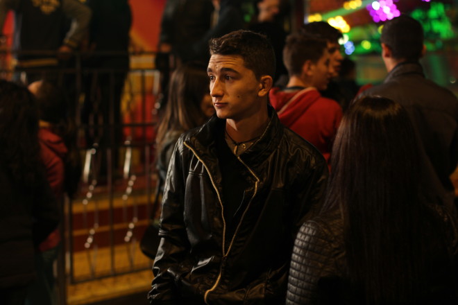 young dark skinned dark haired man looking lonely in crowd