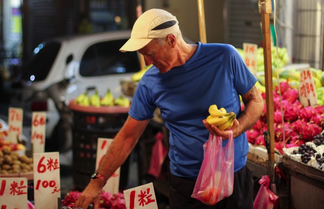 tourist buying fruit from street stall