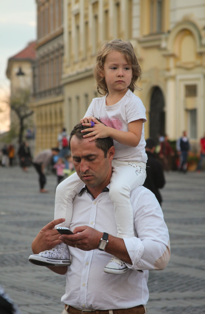 little girl riding on her dads shoulders