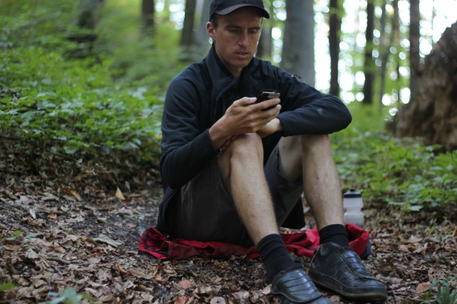 man reading on smartphone in forest