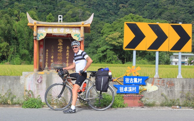 cyclist stopped at roadside church alter in taiwan