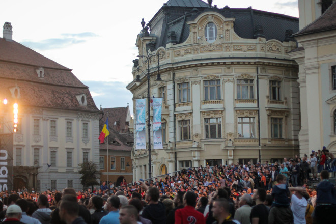 crowd of peopel watching event in sibiu romania central square and city hall in the background