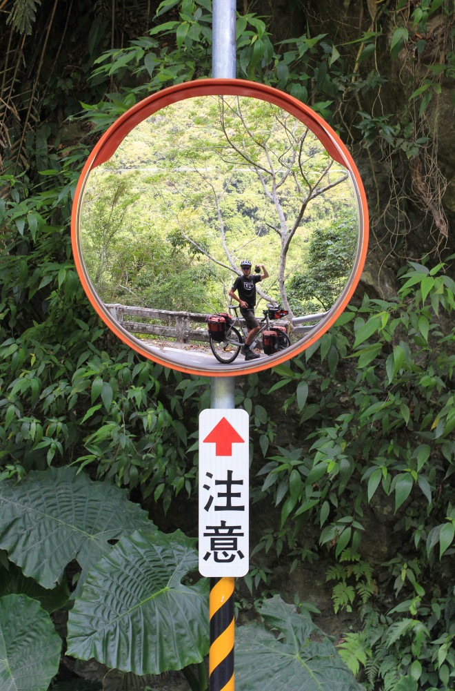 cyclist taking photo using road mirror