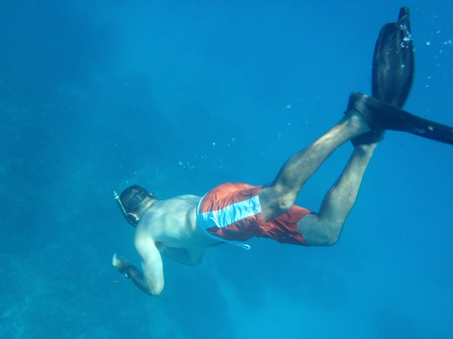 man freediving in ocean