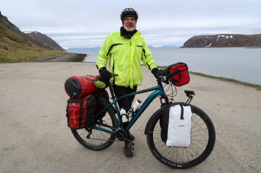Retired German man with fully loaded touring bicycle in Norway