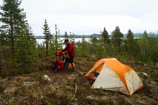 Bicycle camping on a mountain above a lake in Finland