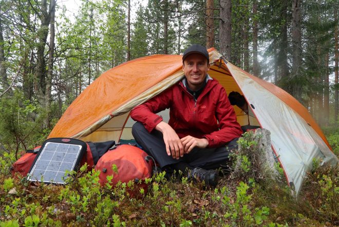 Darren Alff smiling while camping in tent in Finland