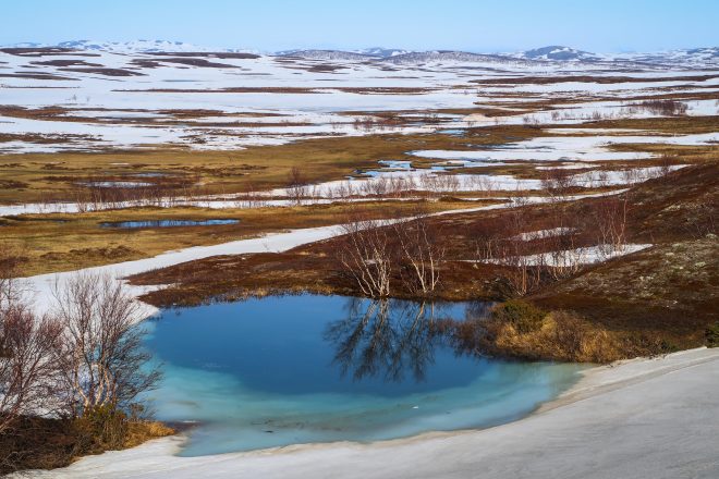 Frozen blue pond in nordkapp snowy arctic region