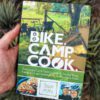 bike camp cook book held in hand