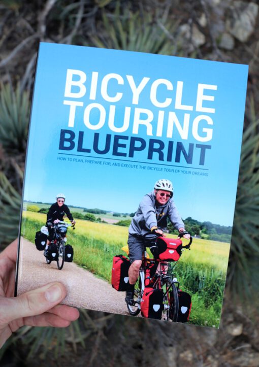 Holding a copy of "The Bicycle Touring Blueprint" in my hand