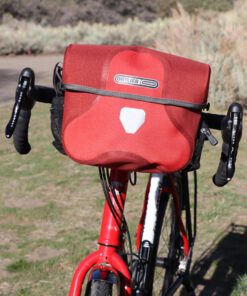 Red Ortlieb Ultimate 6 7 liter waterproof handlebar bag on touring bicycle